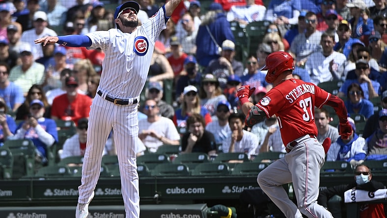 May 30, 2021; Chicago, Illinois, USA; Chicago Cubs first baseman Kris Bryant (17) leaps for the ball as Cincinnati Reds catcher Tyler Stephenson (37) is safe at first base during the fourth inning at Wrigley Field. Mandatory Credit: Matt Marton-USA TODAY Sports