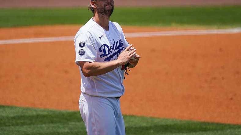 May 30, 2021; Los Angeles, California, USA; Los Angeles Dodgers starting pitcher Clayton Kershaw (22) rubs up a new baseball after giving up a two-run home run to San Francisco Giants shortstop Mauricio Dubon (not pictured) during the first inning at Dodger Stadium. Mandatory Credit: Robert Hanashiro-USA TODAY Sports