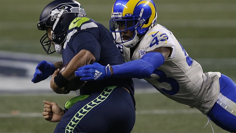 Jan 9, 2021; Seattle, Washington, USA; Los Angeles Rams safety John Johnson III (43) tackles Seattle Seahawks quarterback Russell Wilson (3) during the fourth quarter at Lumen Field. Mandatory Credit: Joe Nicholson-USA TODAY Sports