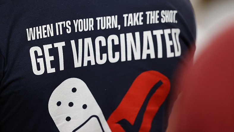 Feb 7, 2020; Tampa, FL, USA; A fan wears a shirt reminding people to get a COVID-19 vaccine during the first quarter of Super Bowl LV between the Kansas City Chiefs and the Tampa Bay Buccaneersat Raymond James Stadium.  Mandatory Credit: Kim Klement-USA TODAY Sports