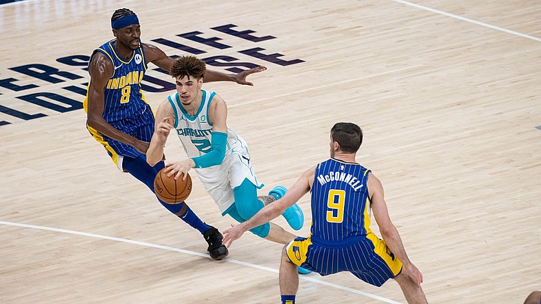 May 18, 2021; Indianapolis, Indiana, USA; Charlotte Hornets guard LaMelo Ball (2) dribbles the ball while Indiana Pacers forward Justin Holiday (8) defends  in the third quarter at Bankers Life Fieldhouse. Mandatory Credit: Trevor Ruszkowski-USA TODAY Sports