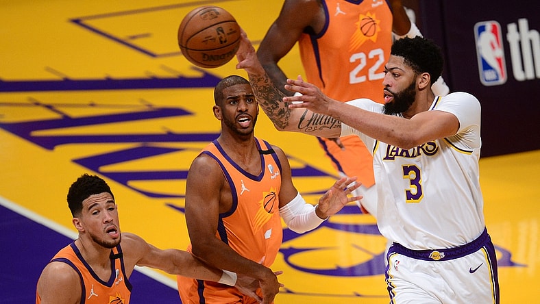 May 30, 2021; Los Angeles, California, USA; Los Angeles Lakers forward Anthony Davis (3) passes the ball against Phoenix Suns guard Chris Paul (3) and guard Devin Booker (1) during the first half in game four of the first round of the 2021 NBA Playoffs. at Staples Center. Mandatory Credit: Gary A. Vasquez-USA TODAY Sports