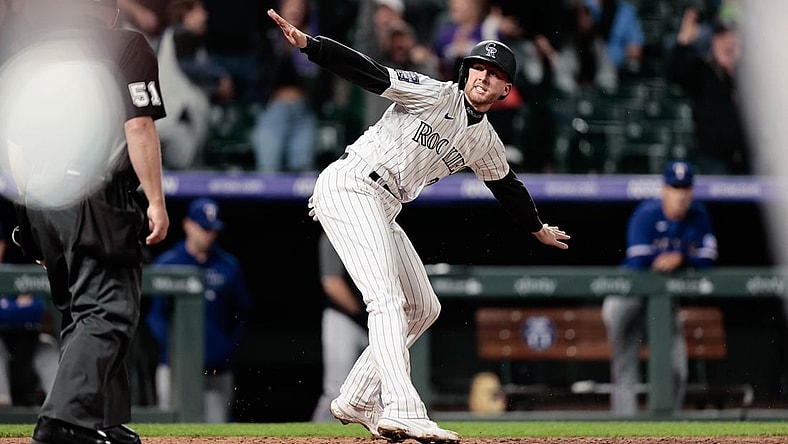 Jun 1, 2021; Denver, Colorado, USA; Colorado Rockies second baseman Ryan McMahon (24) reacts after reaching home on a play in the eleventh inning against the Texas Rangers at Coors Field. Mandatory Credit: Isaiah J. Downing-USA TODAY Sports