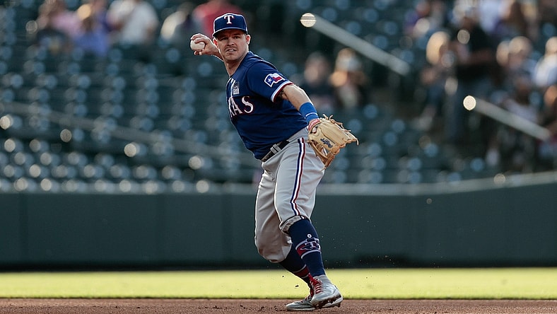Jun 2, 2021; Denver, Colorado, USA; Texas Rangers third baseman Brock Holt (16) makes a throw to first for an out in the first inning against the Colorado Rockies at Coors Field. Mandatory Credit: Isaiah J. Downing-USA TODAY Sports