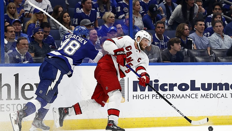 Jun 3, 2021; Tampa, Florida, USA; Carolina Hurricanes center Jordan Staal (11) passes the puck as Tampa Bay Lightning defenseman Mikhail Sergachev (98) defends during the second period in game three of the second round of the 2021 Stanley Cup Playoffs at Amalie Arena. Mandatory Credit: Kim Klement-USA TODAY Sports