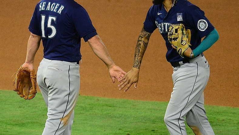 Jun 3, 2021; Anaheim, California, USA; Seattle Mariners third baseman Kyle Seager (15) and shortstop J.P. Crawford (3) celebrate the 6-2 victory against the Los Angeles Angels at Angel Stadium. Mandatory Credit: Gary A. Vasquez-USA TODAY Sports