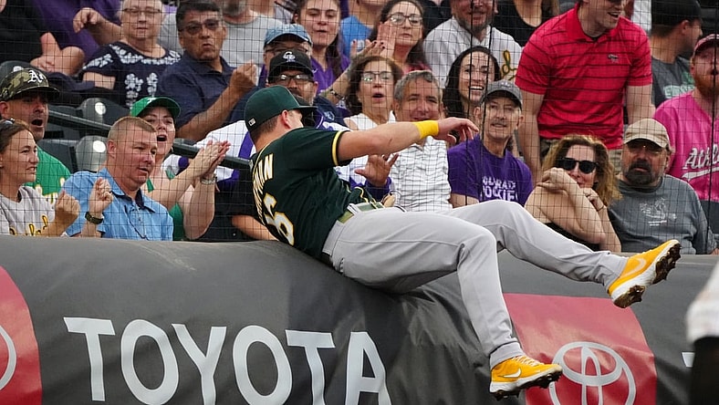 Jun 5, 2021; Denver, Colorado, USA; Oakland Athletics third baseman Matt Chapman (26) attempts to field a foul ball in the first inning against the Colorado Rockies at Coors Field. Mandatory Credit: Ron Chenoy-USA TODAY Sports