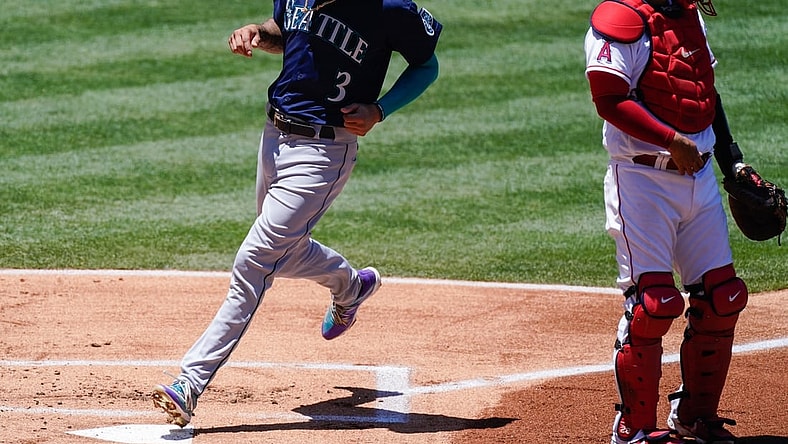Jun 6, 2021; Anaheim, California, USA; Seattle Mariners shortstop J.P. Crawford (3) scores in the first inning on a sacrifice fly by Kyle Seager (not pictured) at Angel Stadium. Right is Los Angeles Angels catcher Kurt Suzuki (24). Mandatory Credit: Robert Hanashiro-USA TODAY Sports