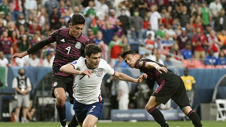 Jun 6, 2021; Denver, Colorado, USA;  United States forward Gio Reyna (7) trips up going after the ball as Mexico midfielder Edson Alvarez (4) defends on the play in the first half during the 2021 CONCACAF Nations League Finals soccer series final match at Empower Field at Mile High. Mandatory Credit: John Leyba-USA TODAY Sports