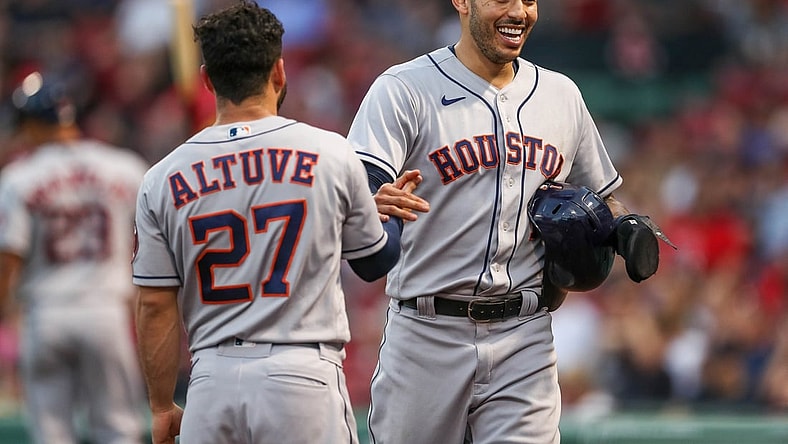 Jun 9, 2021; Boston, Massachusetts, USA; Houston Astros shortstop Carlos Correa (1) and second baseman Jose Altuve (27) react after Correa scored during the third inning against the Boston Red Sox at Fenway Park. Mandatory Credit: Paul Rutherford-USA TODAY Sports