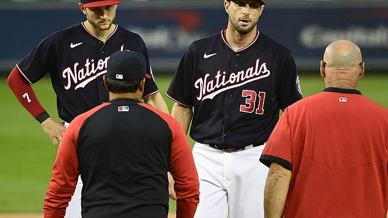 Jun 11, 2021; Washington, District of Columbia, USA;  Washington Nationals starting pitcher Max Scherzer (31) stands on the pitcher's mound as manager Dave Martinez (4) and the team trainer approach during the first inning against the San Francisco Giants at Nationals Park. Mandatory Credit: Tommy Gilligan-USA TODAY Sports