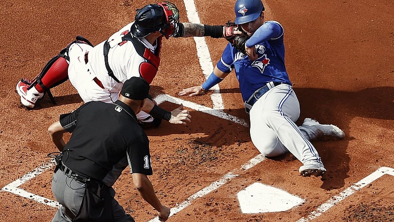 Jun 12, 2021; Boston, Massachusetts, USA; Boston Red Sox catcher Christian Vazquez (7) tags out Toronto Blue Jays second baseman Joe Panik (right) at home plate during the second inning at Fenway Park. Mandatory Credit: Winslow Townson-USA TODAY Sports