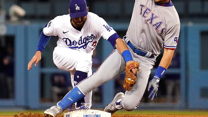 Jun 12, 2021; Los Angeles, California, USA; Texas Rangers first baseman Nate Lowe (30) is tagged out by Los Angeles Dodgers left fielder Chris Taylor (3) after sliding past the base in the third inning at Dodger Stadium. Mandatory Credit: Robert Hanashiro-USA TODAY Sports