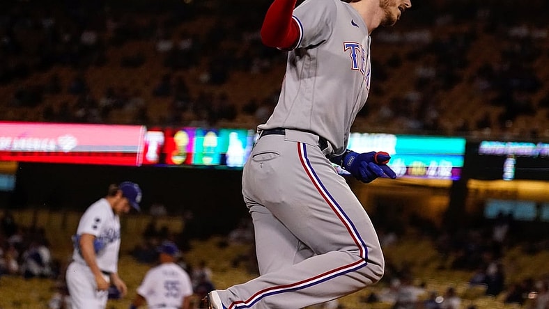 Jun 12, 2021; Los Angeles, California, USA; Texas Rangers catcher Jonah Heim (right) rounds third base after hitting a two run home run against Los Angeles Dodgers starting pitcher Trevor Bauer (background) in the fourth inning at Dodger Stadium. Mandatory Credit: Robert Hanashiro-USA TODAY Sports