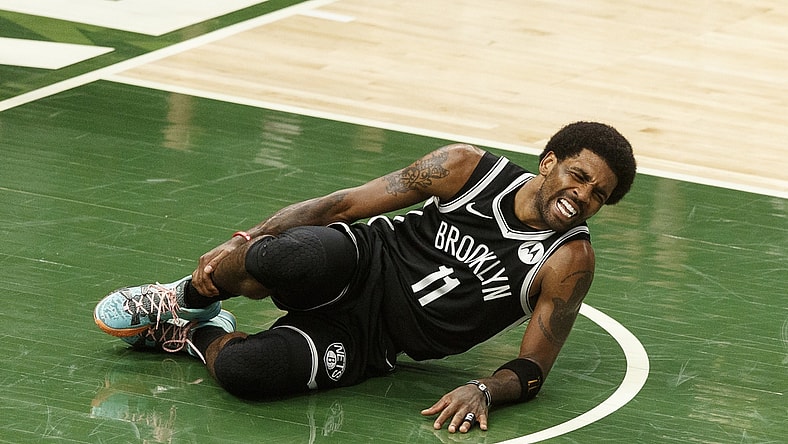 Jun 13, 2021; Milwaukee, Wisconsin, USA;  Brooklyn Nets guard Kyrie Irving (11) grabs his leg after being injured during the second quarter against the Milwaukee Bucks during game four in the second round of the 2021 NBA Playoffs. at Fiserv Forum. Mandatory Credit: Jeff Hanisch-USA TODAY Sports