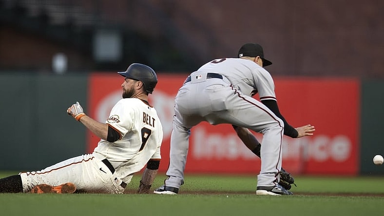 Jun 14, 2021; San Francisco, California, USA; San Francisco Giants first baseman Brandon Belt (9) slides safely into second base with a double ahead of the relay to  Arizona Diamondbacks shortstop Nick Ahmed (13) during the fifth inning at Oracle Park. Mandatory Credit: D. Ross Cameron-USA TODAY Sports