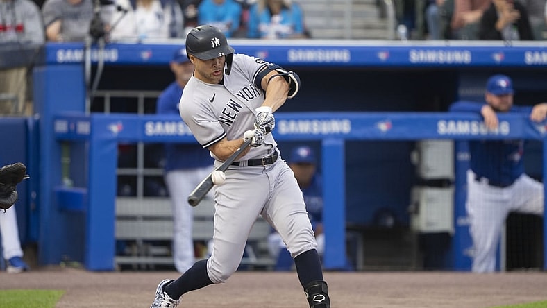 Jun 16, 2021; Buffalo, New York, CAN; New York Yankees designated hitter Giancarlo Stanton (27) hits a sacrifice fly to drive in a run during the first inning against the Toronto Blue Jays at Sahlen Field. Mandatory Credit: Gregory Fisher-USA TODAY Sports