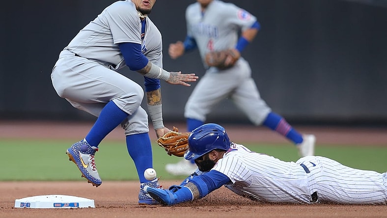 Jun 16, 2021; New York City, New York, USA; New York Mets third baseman Jonathan Villar (1) steals second base as Chicago Cubs shortstop Javier Baez (9) can't handle the throw during the first inning at Citi Field. Mandatory Credit: Brad Penner-USA TODAY Sports