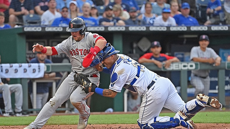 Jun 18, 2021; Kansas City, Missouri, USA;  Kansas City Royals catcher Salvador Perez (13) tags out Boston Red Sox base runner Christian Arroyo (39) attempting to score at home plate during the third inning at Kauffman Stadium. Mandatory Credit: Peter Aiken-USA TODAY Sports