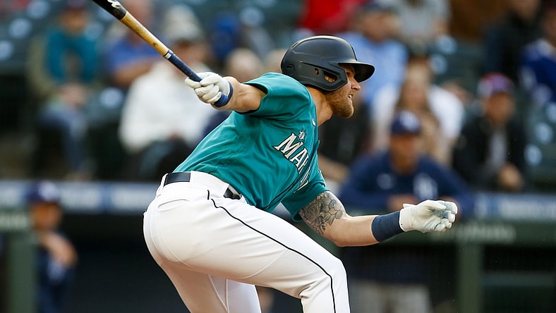 Jun 18, 2021; Seattle, Washington, USA; Seattle Mariners first baseman Jake Bauers (5) hits an RBI single against the Tampa Bay Rays during the first inning at T-Mobile Park. Mandatory Credit: Joe Nicholson-USA TODAY Sports