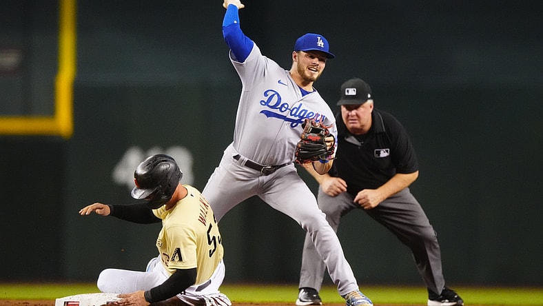 Jun 18, 2021; Phoenix, Arizona, USA; Los Angeles Dodgers shortstop Gavin Lux throws to first after forcing out sliding Arizona Diamondbacks base runner Christian Walker in the fourth inning at Chase Field. Mandatory Credit: Mark J. Rebilas-USA TODAY Sports