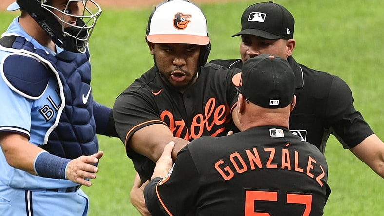 Jun 19, 2021; Baltimore, Maryland, USA;  Baltimore Orioles coach Fredi Gonzalez (57) holds back Baltimore Orioles third baseman Maikel Franco (3) after being hit by a pitch against the Toronto Blue Jays in the fourth inning at Oriole Park at Camden Yards. Mandatory Credit: Tommy Gilligan-USA TODAY Sports