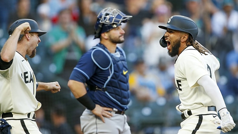 Jun 19, 2021; Seattle, Washington, USA; Seattle Mariners shortstop J.P. Crawford (right) celebrates with catcher Tom Murphy (left) after scoring Murphy with a grand-slam home run against the Tampa Bay Rays during the second inning at T-Mobile Park. Tampa Bay Rays catcher Mike Zunino (10) looks on in the background. Mandatory Credit: Joe Nicholson-USA TODAY Sports