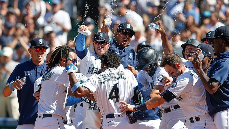 Jun 20, 2021; Seattle, Washington, USA; Seattle Mariners left fielder Shed Long Jr. (4) is mobbed by his teammates at home plate after hitting a walk-off grand slam against the Tampa Bay Rays during the tenth inning at T-Mobile Park. Mandatory Credit: Jennifer Buchanan-USA TODAY Sports
