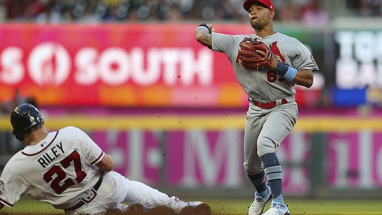 Jun 20, 2021; Atlanta, Georgia, USA; St. Louis Cardinals shortstop Edmundo Sosa (63) turns a double play over Atlanta Braves third baseman Austin Riley (27) in the fourth inning at Truist Park. Mandatory Credit: Brett Davis-USA TODAY Sports