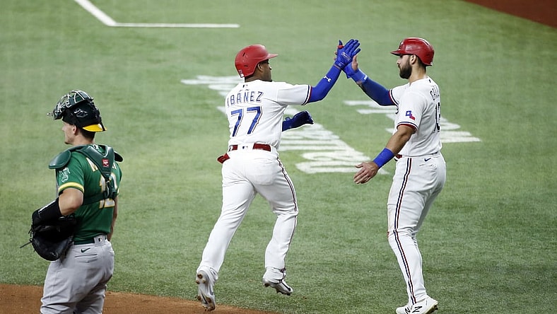 Jun 21, 2021; Arlington, Texas, USA; Texas Rangers second baseman Andy Ibanez (77) is congratulated by right fielder Joey Gallo (13) after hitting a three run home run in the first inning against the Oakland Athletics at Globe Life Field. Mandatory Credit: Tim Heitman-USA TODAY Sports