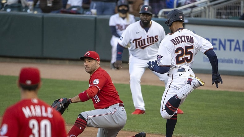 Jun 21, 2021; Minneapolis, Minnesota, USA; Minnesota Twins center fielder Byron Buxton (25) reaches first base before Cincinnati Reds first baseman Joey Votto (19) can catch the ball for a single in the second inning at Target Field. Mandatory Credit: Jesse Johnson-USA TODAY Sports
