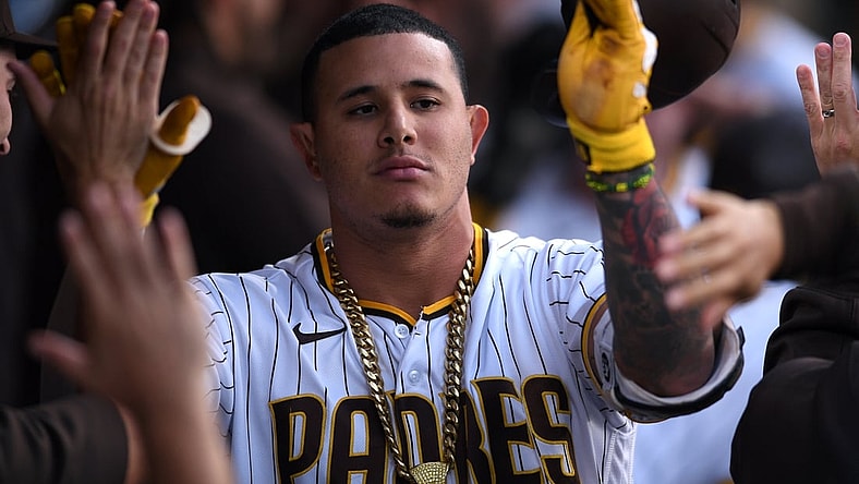 Jun 21, 2021; San Diego, California, USA; San Diego Padres third baseman Manny Machado (13) is congratulated in the dugout after hitting a three-run home run during the first inning against the Los Angeles Dodgers at Petco Park. Mandatory Credit: Orlando Ramirez-USA TODAY Sports