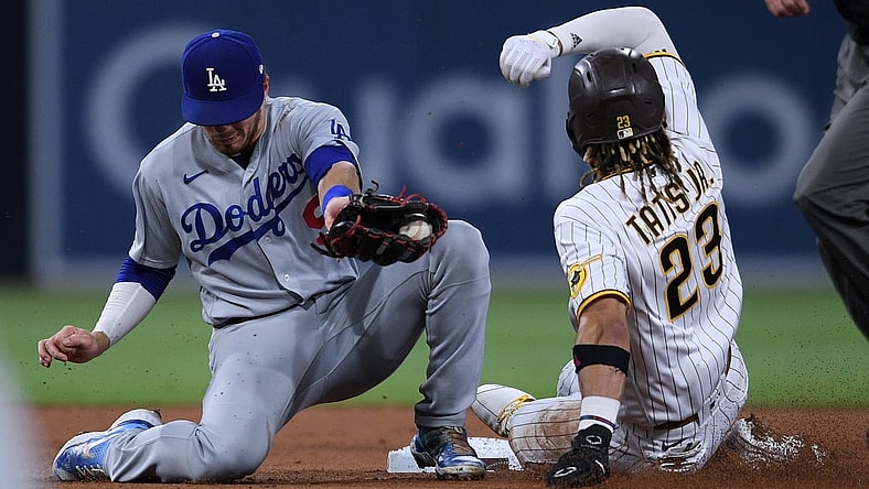 Jun 23, 2021; San Diego, California, USA; San Diego Padres shortstop Fernando Tatis Jr. (23) steals second base ahead of the tag by Los Angeles Dodgers shortstop Gavin Lux (left) during the third inning at Petco Park. Mandatory Credit: Orlando Ramirez-USA TODAY Sports