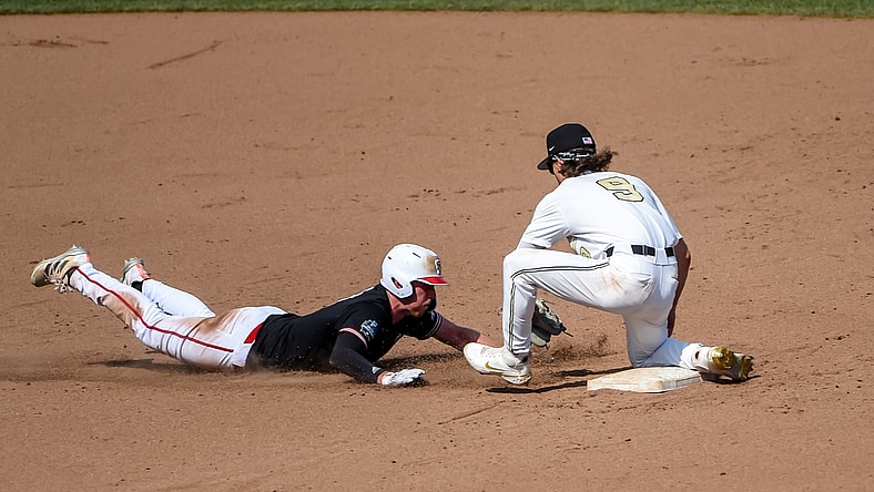Jun 25, 2021; Omaha, Nebraska, USA;  Vanderbilt Commodores infielder Carter Young (9) tags out NC State Wolfpack first baseman Sam Highfill (17) on a pick off in the seventh inning at TD Ameritrade Park. Mandatory Credit: Steven Branscombe-USA TODAY Sports