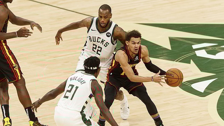 Jun 25, 2021; Milwaukee, Wisconsin, USA; Atlanta Hawks guard Trae Young (11) looks to pass the ball while defended by Milwaukee Bucks forward Khris Middleton (22) and guard Jrue Holiday (21) during the third quarter during game two of the Eastern Conference Finals for the 2021 NBA Playoffs at Fiserv Forum. Mandatory Credit: Jeff Hanisch-USA TODAY Sports