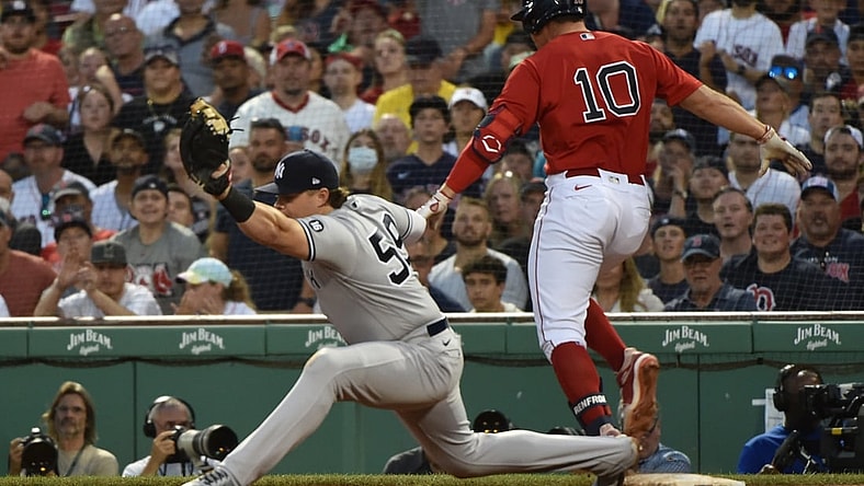 Jun 26, 2021; Boston, Massachusetts, USA; New York Yankees first baseman Luke Voit (59) stretches to make the catch but Boston Red Sox right fielder Hunter Renfroe (10) beats out the throw during the third inning at Fenway Park. Mandatory Credit: Bob DeChiara-USA TODAY Sports