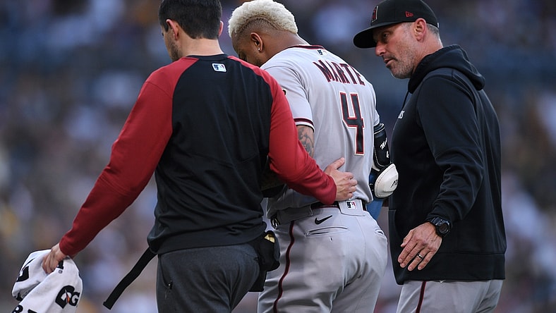 Jun 26, 2021; San Diego, California, USA; Arizona Diamondbacks center fielder Ketel Marte (4) is accompanied off the field by manager Torey Lovullo (right) after an injury during the first inning against the San Diego Padres at Petco Park. Mandatory Credit: Orlando Ramirez-USA TODAY Sports