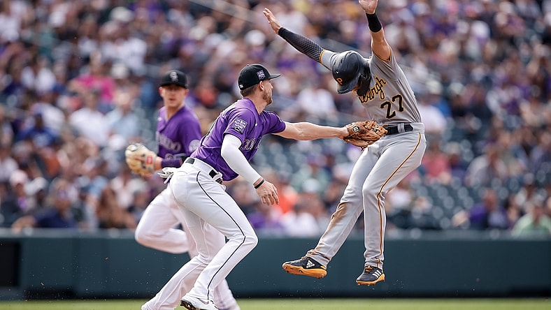 Jun 28, 2021; Denver, Colorado, USA; Pittsburgh Pirates second baseman Kevin Newman (27) avoids the tag from Colorado Rockies second baseman Ryan McMahon (24) as he runs to third in the fifth inning at Coors Field. Mandatory Credit: Isaiah J. Downing-USA TODAY Sports