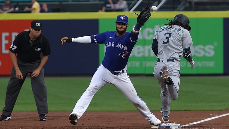 Jun 30, 2021; Buffalo, New York, USA; Seattle Mariners shortstop J.P. Crawford (3) is safe at first base as Toronto Blue Jays first baseman Lourdes Gurriel Jr. (center) misses the catch during the third inning at Sahlen Field. Mandatory Credit: Timothy T. Ludwig-USA TODAY Sports