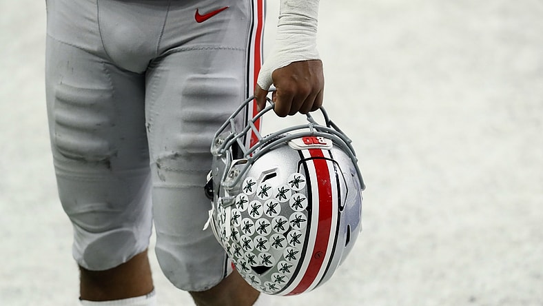 Dec 19, 2020; Indianapolis, Indiana, USA; A member of the Ohio State Buckeyes carries his helmet off the field after defeating the Northwestern Wildcats at Lucas Oil Stadium. Mandatory Credit: Aaron Doster-USA TODAY Sports