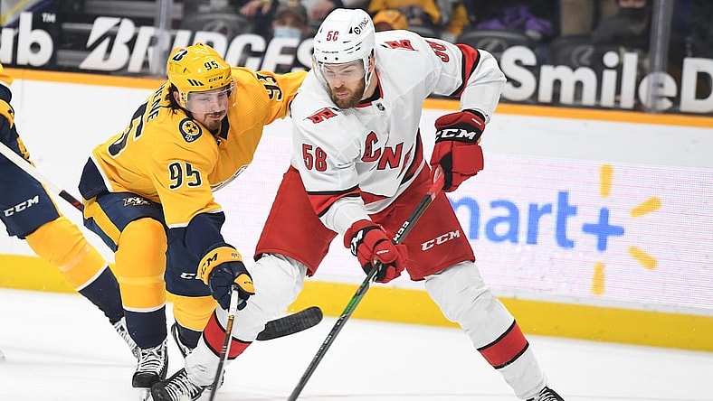 May 8, 2021; Nashville, Tennessee, USA; Carolina Hurricanes defenseman Jani Hakanpaa (58) looks to pass the puck as he is pressured by Nashville Predators center Matt Duchene (95) during the first period at Bridgestone Arena. Mandatory Credit: Christopher Hanewinckel-USA TODAY Sports