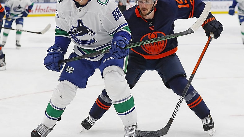 May 8, 2021; Edmonton, Alberta, CAN; Vancouver Canucks defensemen Nate Schmidt (88) and Edmonton Oilers forward Josh Archibald (15) chase a loose puck during the third period at Rogers Place. Mandatory Credit: Perry Nelson-USA TODAY Sports