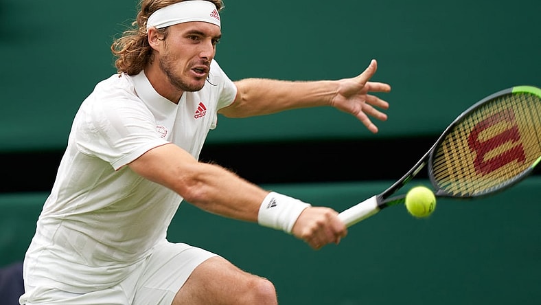 Jun 28, 2021; London, United Kingdom;   Stefanos Tsitsipas of Greece in action against third seed Francis Tiafoe (USA) on Court Number one in the first round at All England Lawn Tennis and Croquet Club. Mandatory Credit: Peter van den Berg-USA TODAY Sports