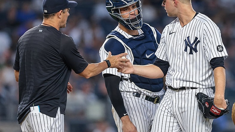 Jun 28, 2021; Bronx, New York, USA; New York Yankees starting pitcher Michael King (73) hands the ball to  manager Aaron Boone (17) while talking with catcher Gary Sanchez (24) during the fifth inning against the Los Angeles Angels at Yankee Stadium. Mandatory Credit: Vincent Carchietta-USA TODAY Sports