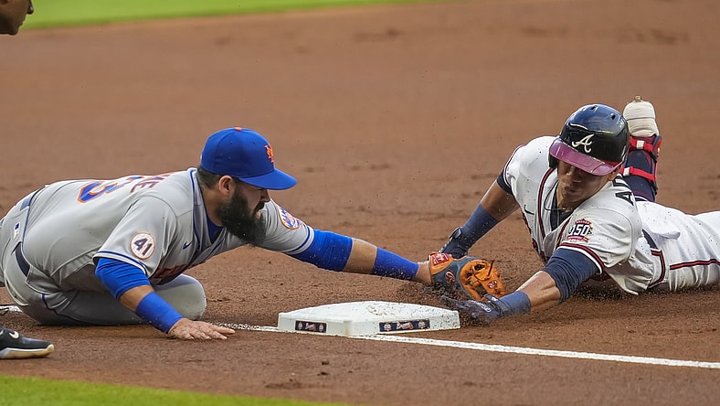 Jul 1, 2021; Cumberland, Georgia, USA; Atlanta Braves right fielder Ehire Adrianza (23) dives into third base against New York Mets third baseman Luis Guillorme (13) after hitting a triple during the first inning at Truist Park. Mandatory Credit: Dale Zanine-USA TODAY Sports