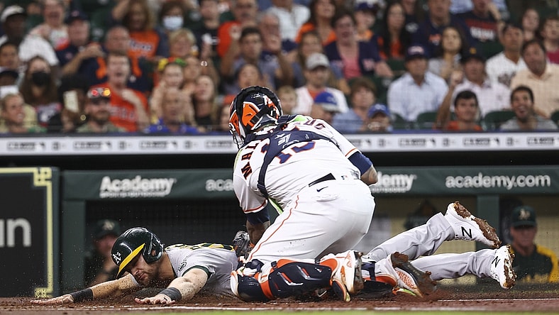Jul 6, 2021; Houston, Texas, USA; Oakland Athletics left fielder Chad Pinder (4) is tagged out by Houston Astros catcher Martin Maldonado (15) at home plate during the first inning at Minute Maid Park. Mandatory Credit: Troy Taormina-USA TODAY Sports