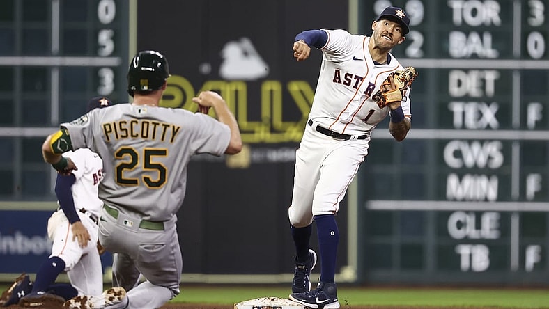 Jul 7, 2021; Houston, Texas, USA; Oakland Athletics right fielder Stephen Piscotty (25) is forced out at second base as Houston Astros shortstop Carlos Correa (1) throws to first base during the fifth inning at Minute Maid Park. Mandatory Credit: Troy Taormina-USA TODAY Sports