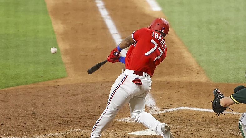 Jul 9, 2021; Arlington, Texas, USA;  Texas Rangers first baseman Andy Ibanez (77) hits an rbi single during the sixth inning against the Oakland Athletics at Globe Life Field. Mandatory Credit: Kevin Jairaj-USA TODAY Sports