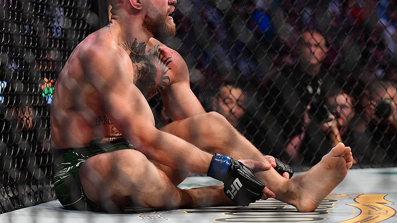 Jul 10, 2021; Las Vegas, Nevada, USA; Conor McGregor holds his leg after suffering an injury against Dustin Poirier during UFC 264 at T-Mobile Arena. Mandatory Credit: Gary A. Vasquez-USA TODAY Sports