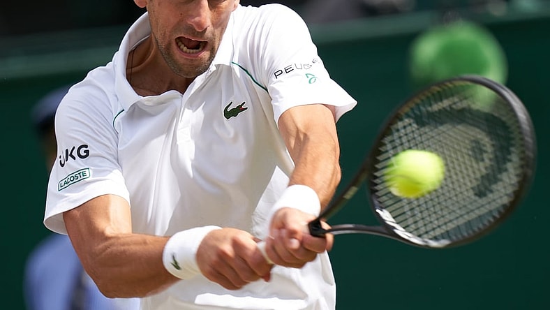 Jul 11, 2021; London, United Kingdom; Novak Djokovic (SRB) hits the ball against Matteo Berrettini (ITA) in the men s final  on Centre Court at All England Lawn Tennis and Croquet Club. Mandatory Credit: Peter van den Berg-USA TODAY Sports